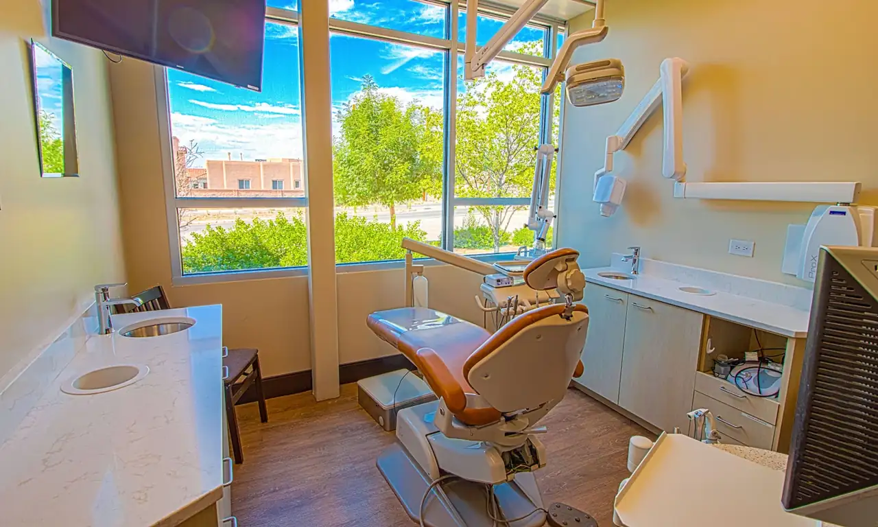 A treatment room at Dr. Slaman & Associates on Alameda Blvd NE, Albuquerque, with a wall of windows beside the dental chair.
