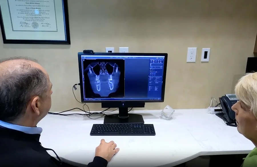 Dr. Slaman reviewing a 3-D scan on screen with a patient.