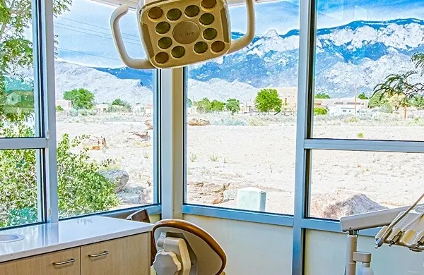 A treatment room with floor-to-ceiling windows looking out to the mountains.