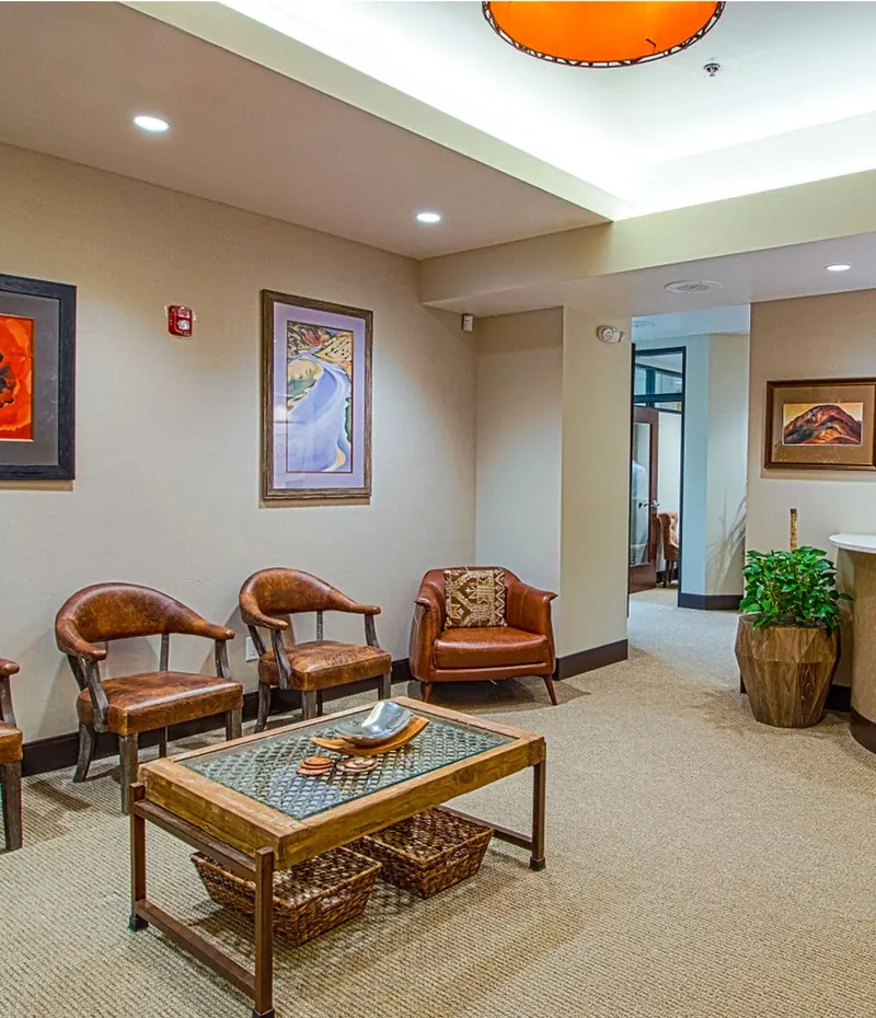 The waiting room, with leather armchairs and the reception desk beyond.