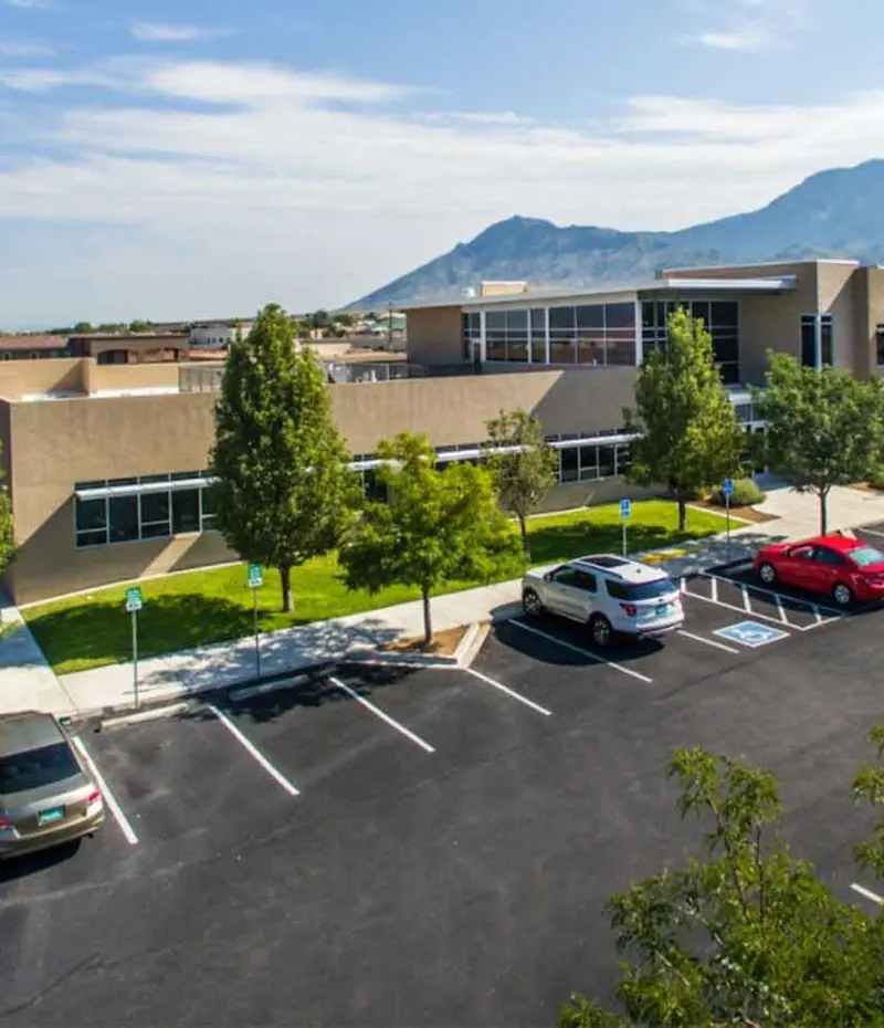 The office building and car park on Alameda Blvd NE, with the mountains behind.
